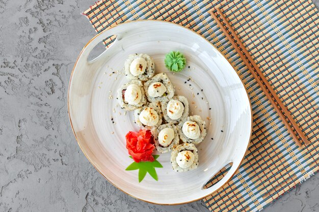 Japanese sushi with sesame seeds and cream icing on gray background