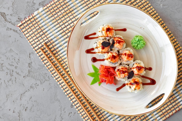 Japanese sushi with sesame seeds and cream icing on gray background