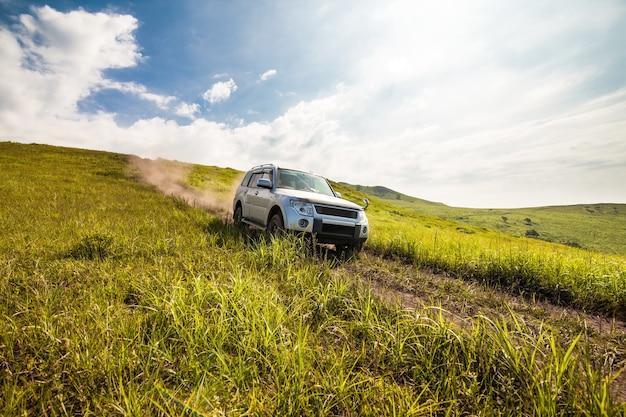 Japanese SUV goes down the hill by dirt road