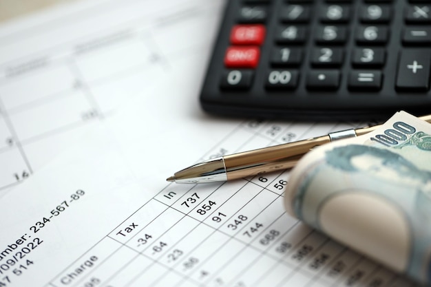 Japanese tax calculations lies on table with calculator pen and japanese yen money bills close up