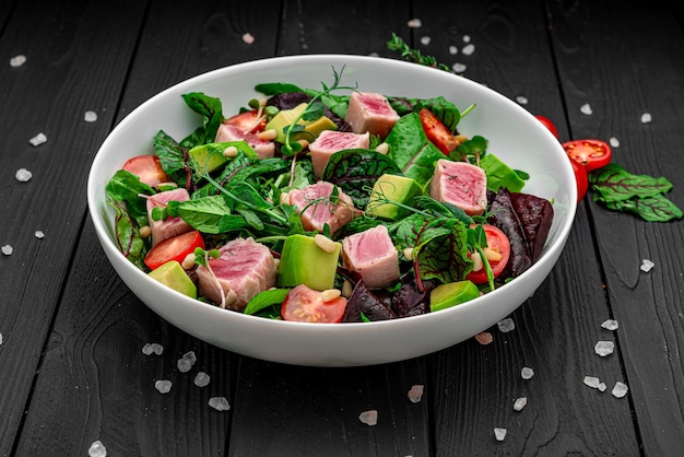 Japanese traditional salad with pieces of mediumrare grilled Ahi tuna and sesame with fresh vegetable on a bowl