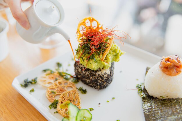 Foto il giapponese umeplum shiso lascia il fuoco selettivo di musubi onigiri e genmai avocado musubi onigiri