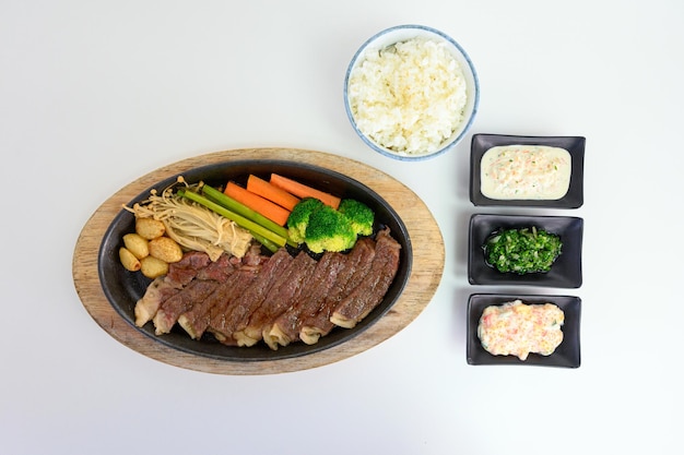 Japanese wagyu beef slices set with vegetables and sauce on pan