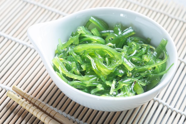 Japanese Wakame Seaweed Salad with Chopsticks close up Healthy vegetarian seafood