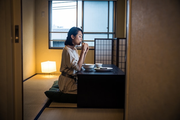 伝統的なアパートで食べる日本人女性