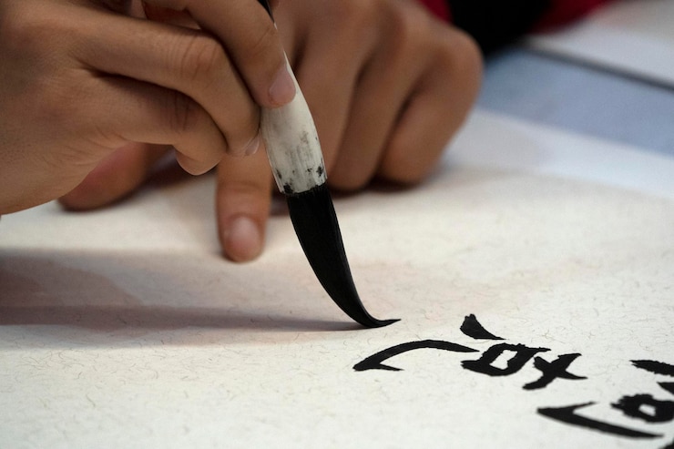 फोटो japanese woman writing name "elisabeth" in ideograms with brush