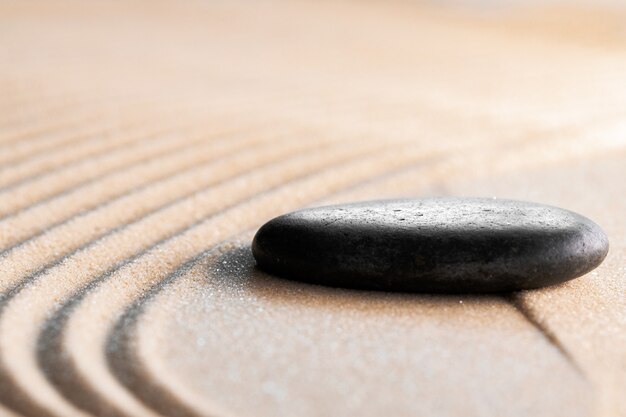 Foto giardino zen giapponese con pietra nella sabbia rastrellata