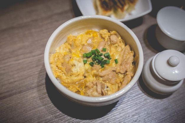 Foto japans eten gyudon of butadon met eierlunchmaaltijd op houten tafel