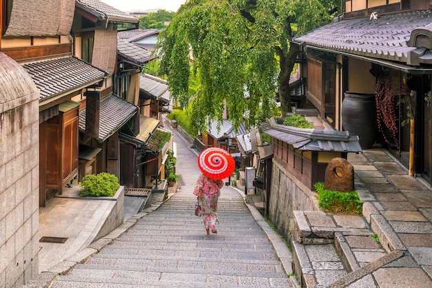 Japans meisje in Yukata met rode paraplu in oude stad Kyoto, Japan