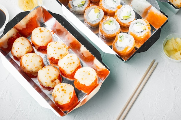 Japans voedselconcept. Catering, verschillende soorten sushi philadelphia-broodjes en gebakken garnalenbroodjes, op witte steen