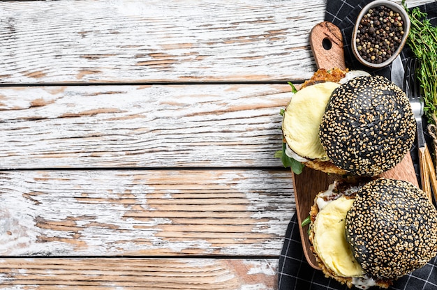 Japanse Black Burger met roerei en rucola. Cheeseburger met zwart broodje. Bovenaanzicht. Kopieer ruimte