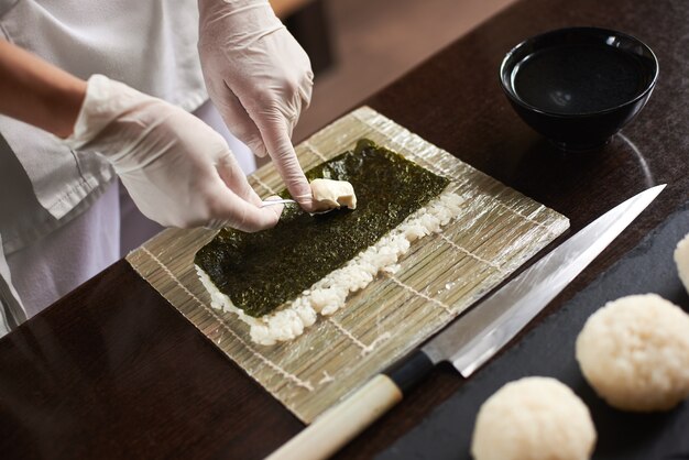 Japanse chef-kok die sushi maakt bij restaurant.