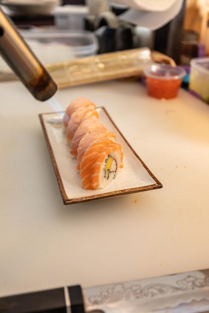 Japanse chef's brandende zalm sushi