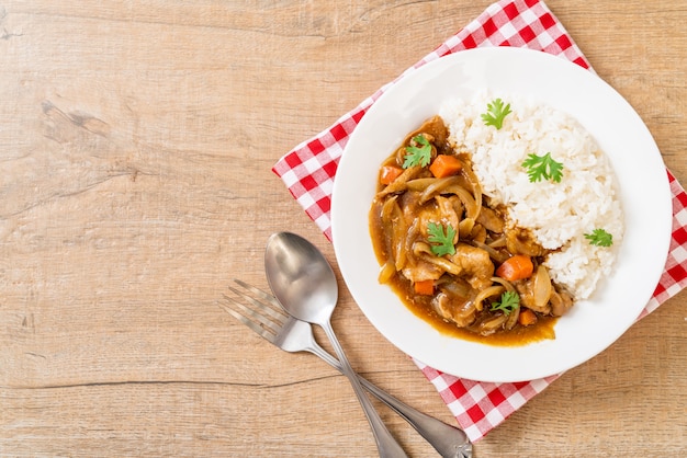 Japanse curryrijst met gesneden varkensvlees, wortel en uien