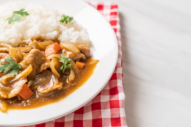 Japanse curryrijst met gesneden varkensvlees, wortel en uien