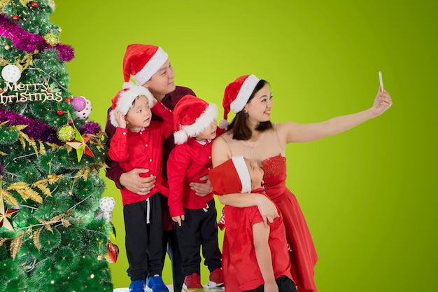 Japanse familie die foto maakt met kerstboom