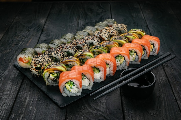 Japanse keuken rollen met zalm tonijn op een zwarte tafel