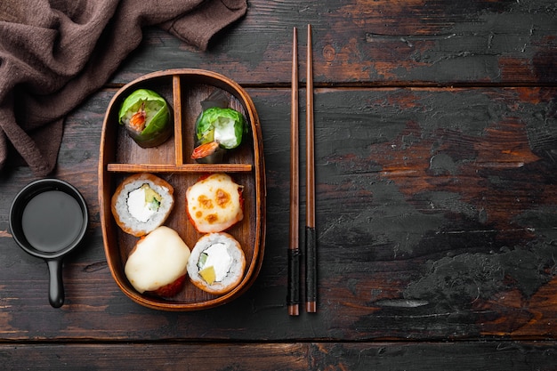 Japanse maaltijd in een doos Bento met sushi roll eice avocado zalm vis set, op oude donkere houten tafel