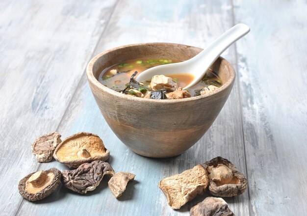 Japanse miso-soep met verse tonijn, gedroogd zeewier, tofu, shiitake gedroogde champignons in een houten kom op de houten achtergrond