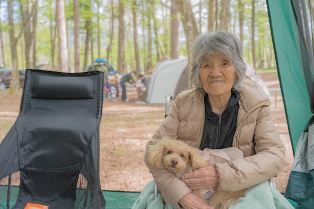 Japanse oude vrouw en een hond in het kamp