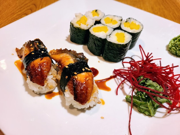 Japanse Sushi Delight met Eel Nigiri en Tamago Maki op wit bord