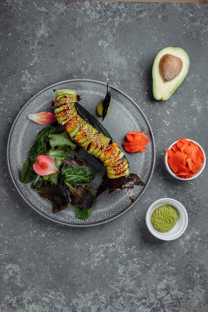 Foto japanse sushi - groene draak. avocado, ui, zalm en sushi kaas. bovenaanzicht.