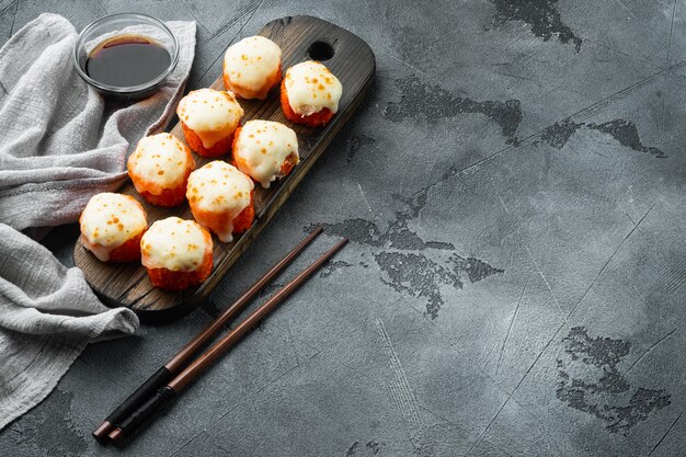 Japanse sushibroodjes genaamd Baked Ebi met wasabi en zalmvisset, op grijze steen