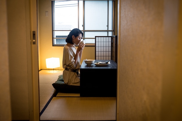 Japanse vrouw die in een traditionele flat eet