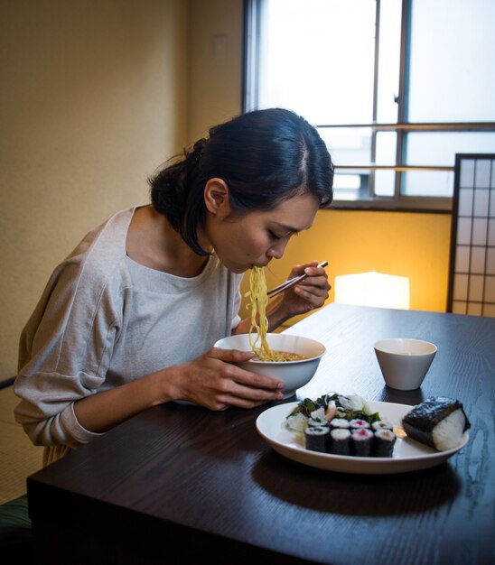 Japanse vrouw die in een traditionele flat eet