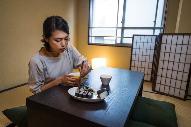 Japanse vrouw die in een traditionele flat eet