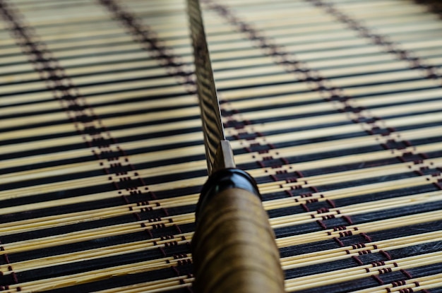 Japanse zwaard katana op bamboe mat Selectieve focus