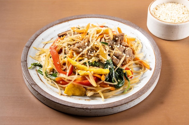 Japchae is stir-fried Korean vermicelli noodles with vegetables and slices beef.