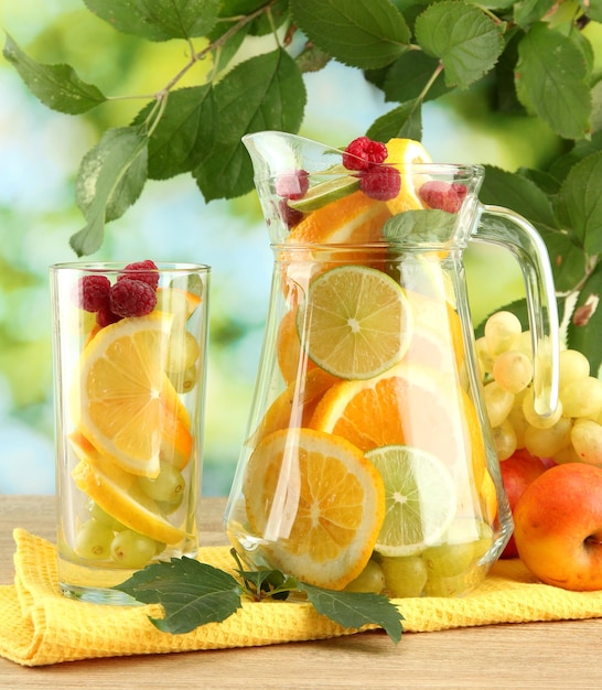 写真 緑色の背景に柑橘類とラズベリーの瓶とガラス