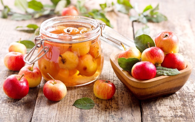 Банка яблочного варенья со свежими фруктами на деревянном столе