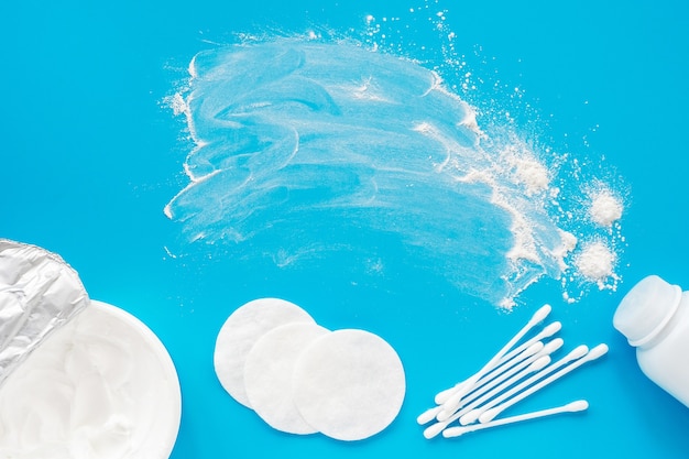 A jar of baby powder and diaper rash cream on a blue background, flatley, top view, copy space for text, mockup.