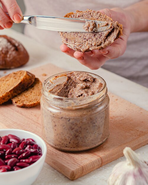 Jar of bean paste. Healthy eating, vegan system. Pleasant appetizing snack - sandwich with bean pate