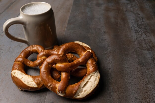 jar of beer and pretzels and pretzels on textured background
