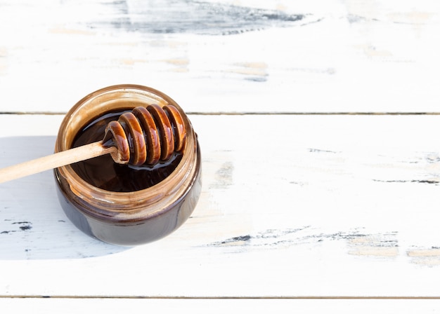 A jar of chocolate dessert, honey or cosmetic masque on white wooden table