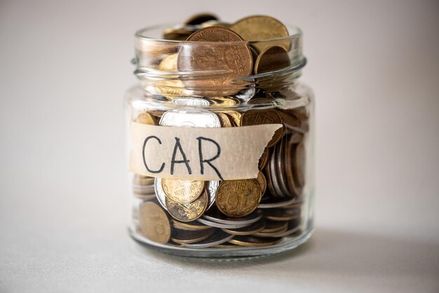 A jar of coins with a tape that says car on it.
