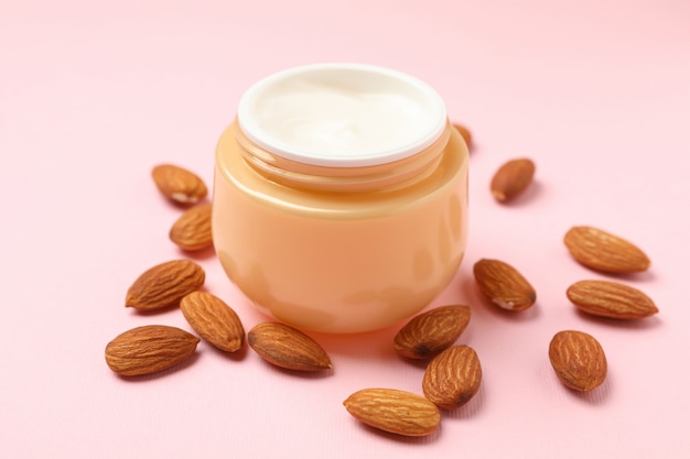 Jar of cosmetic cream and almond
