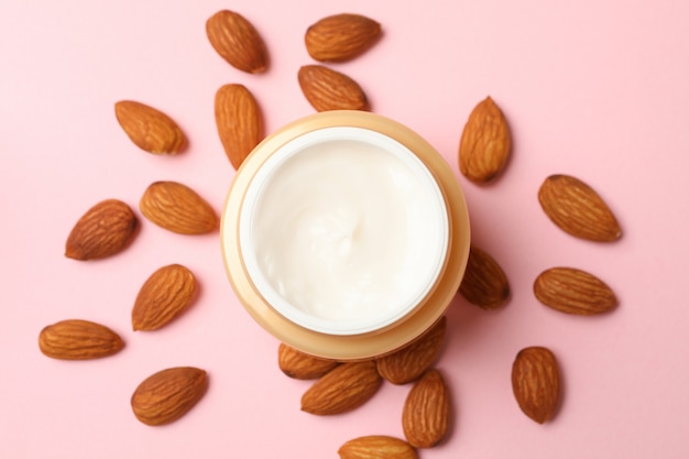 Jar of cosmetic cream and almonds