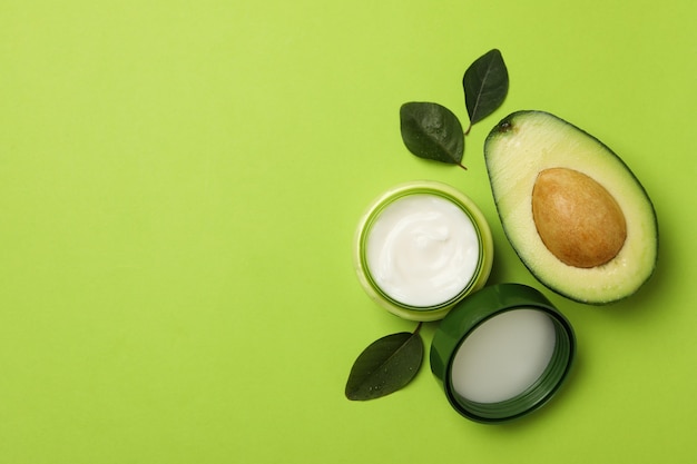 Jar of cosmetic cream, leaves and avocado isolated