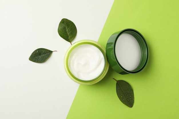 Jar of cosmetic cream and leaves