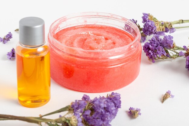 Jar of cosmetic face scrub with flowers and essential oils Organic cosmetics Cosmetics own hands Spa salon skin care