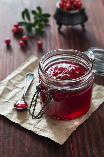 Foto barattolo di marmellata di mirtilli rossi con un cucchiaio e bacche