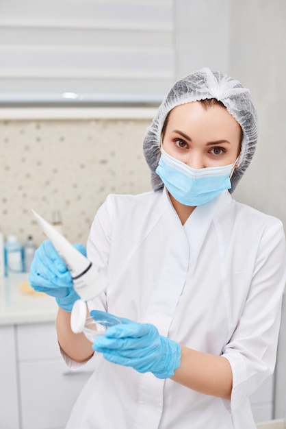 Jar of cream in hands of beautician