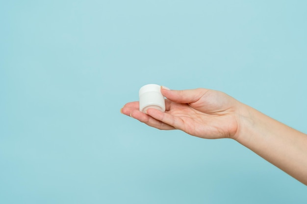 Jar of cream or ointment in hand Packaging cosmetic product