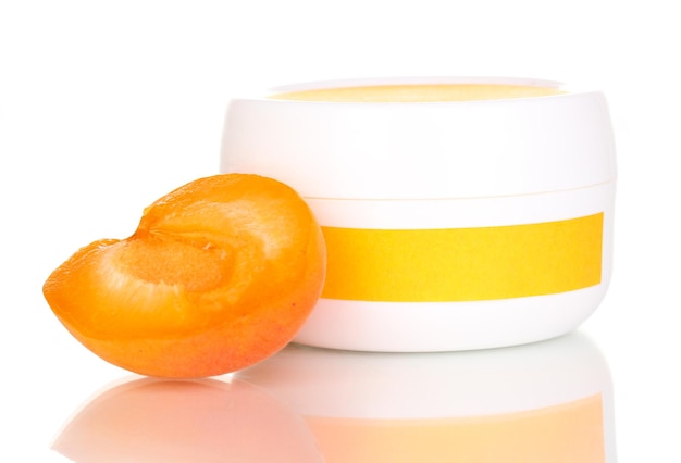 Jar of cream with juicy apricot isolated on white