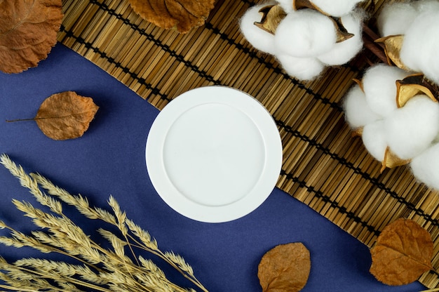 Jar of cream with leaves and cotton