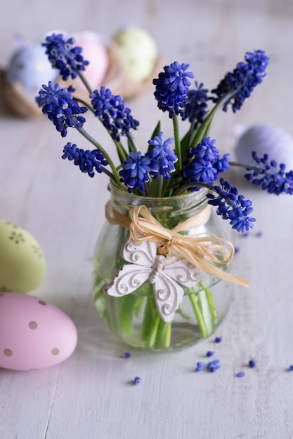 A jar of flowers with easter eggs on the table